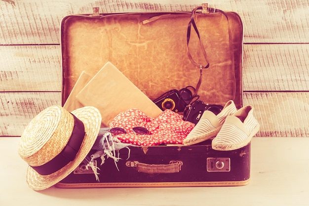 Foto borsa retrò per vocazione estiva con libro fotografico e cappello di vimini