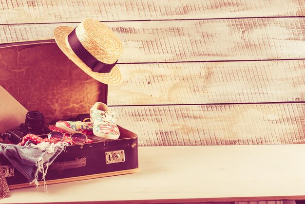 retro bag for summer vocation with photo camera book and wicker hat