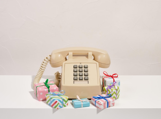 Retro beige phone lies among the creative gifts The idea of greetings and friendly conversations