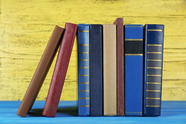 Retro boeken op gele houten achtergrond