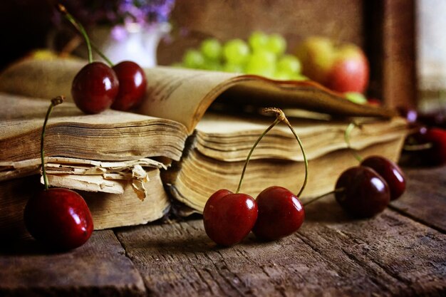 Retro book on wooden background and cherry berry