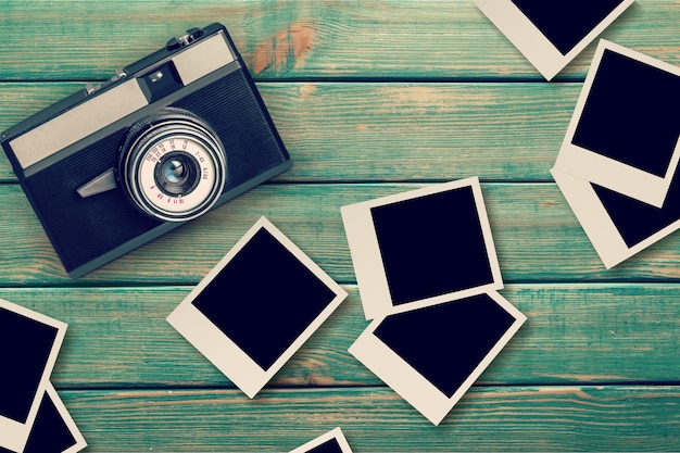 Retro fotocamera e vuoto album vecchio di carta istantanea su tavola di legno - cornice vuota stile vintage