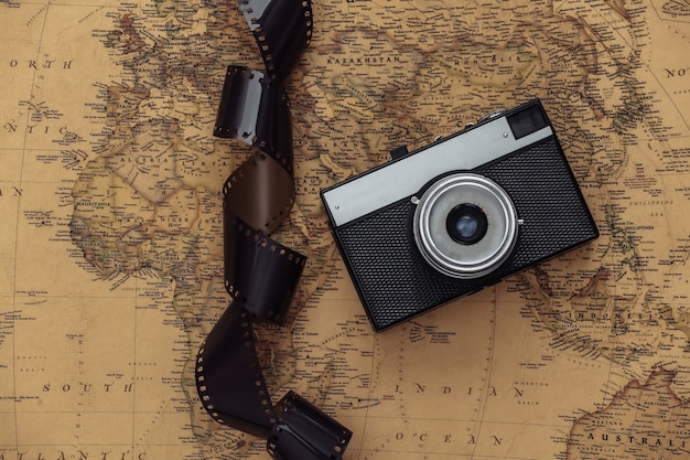 Retro camera en filmband op oude kaart. Reisconcept