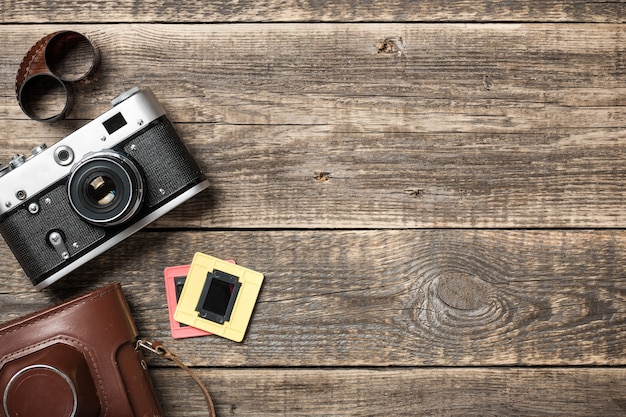 Fotocamera retrò e film su sfondo di legno