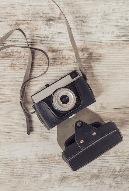 Retro camera on old color wooden table background