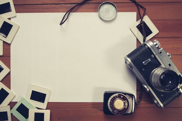 Retro macchina fotografica e alcune vecchie foto sulla tavola di legno