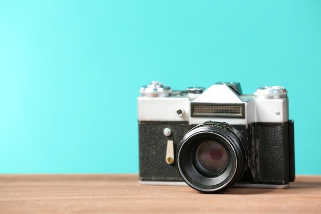 Retro camera on table on green background