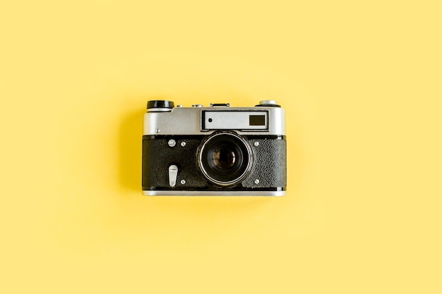 Retro camera on yellow background