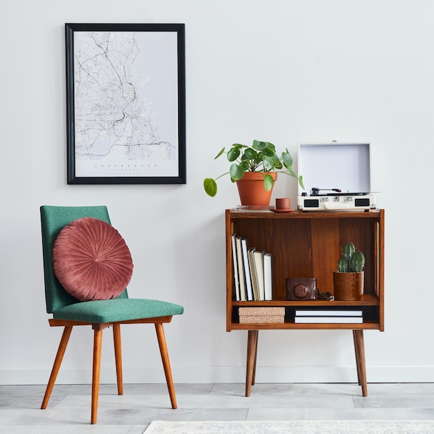 Composizione retrò dell'interno del soggiorno con mock up poster mappa scaffale in legno libro poltrona pianta cactus registratore in vinile decorazione e accessori personali in un elegante arredamento per la casa