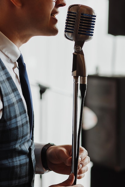 Retro fifties singer with vintage microphone and sunglasses Studio shot