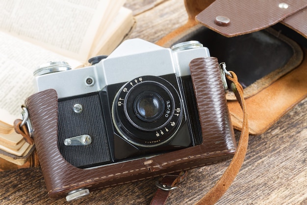 Retro fotocamera met boeken op houten plank