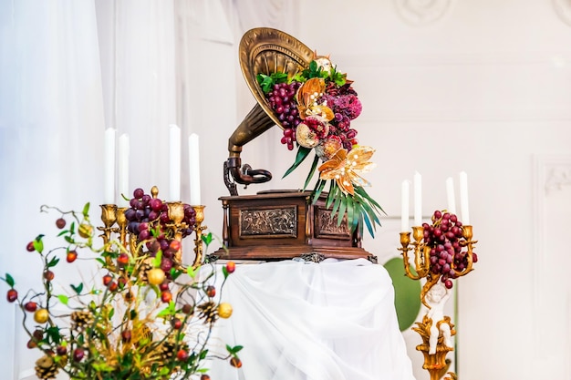 Фото Ретро-граммофон, украшенный фруктами на свадебном банкете, украшающий фуршет