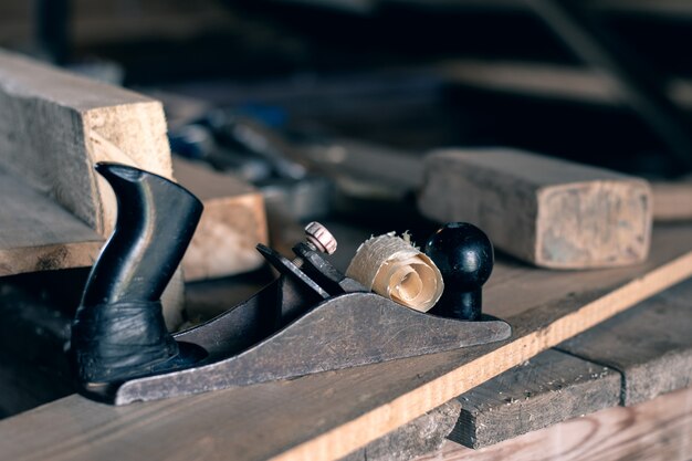 retro hand planer with gloves and mallet on wooden table 