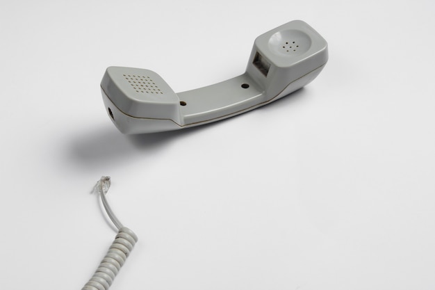 Ретро телефонная трубка с кабелем на белом