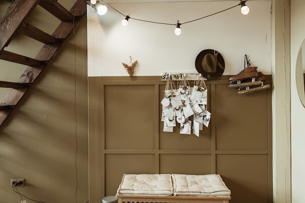 Retro interior design concept with white and brown wall, skates, hat, postcards, stairs