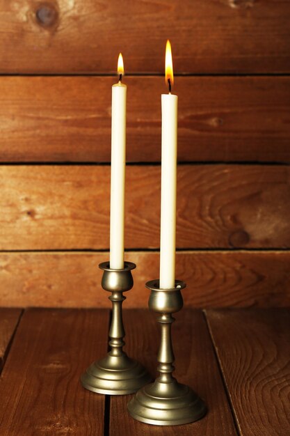 Retro kandelaars met kaarsen op houten achtergrond