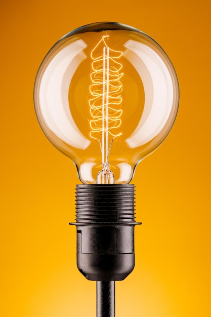 Ретро-лампа на желтом фоне Концепция электричества