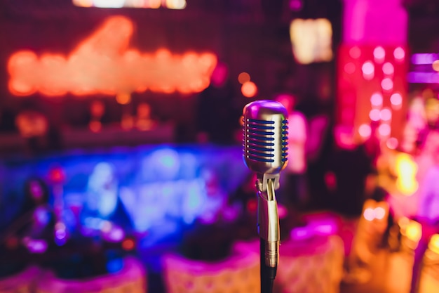 Retro microphone against blur colorful light restaurant background.