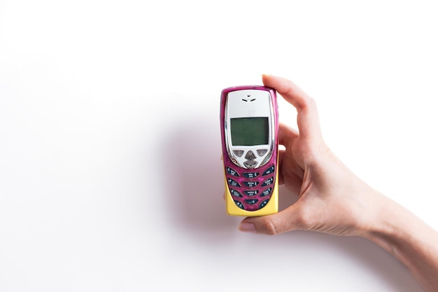 Retro mobiele telefoon met drukknop in de hand op een witte achtergrond