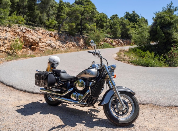 Retro motorcycle chopper stands on a mountain serpentine in\
greece