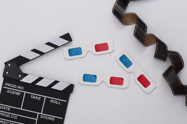 Retro Movie clapper board,  3d glasses and film tape on white background. Filmmaking, Movie production. 80s. Top view