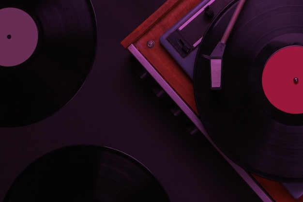 Lettore di musica retrò giradischi in vinile con un disco in vinile su sfondo nero vista dall'alto degli anni '70