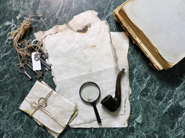 Retro papers and book on detective work table with tools background