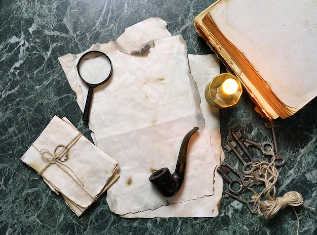 Retro papers and book on detective work table with tools background