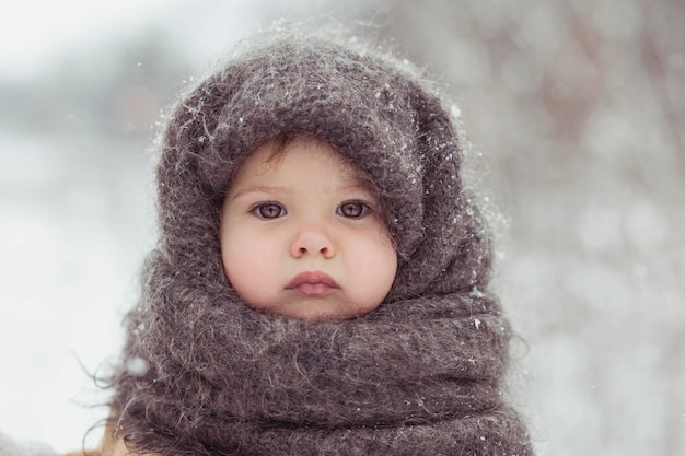 Retro photo of adorable baby in a woolen shawl in winter