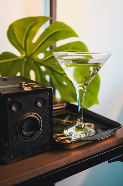 Retro photo camera, tropical leaf and cocktail. vintage vibe Vacation and travel time