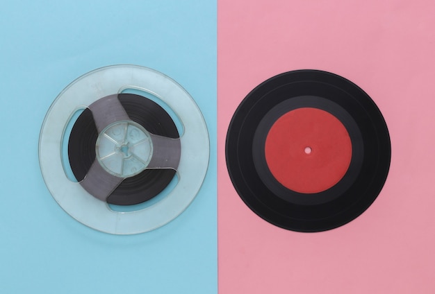 Retro plat lag. Audio magneetbandspoel en vinylplaat op roze blauw pastel