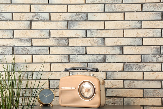 Photo retro radio on table against brick wall