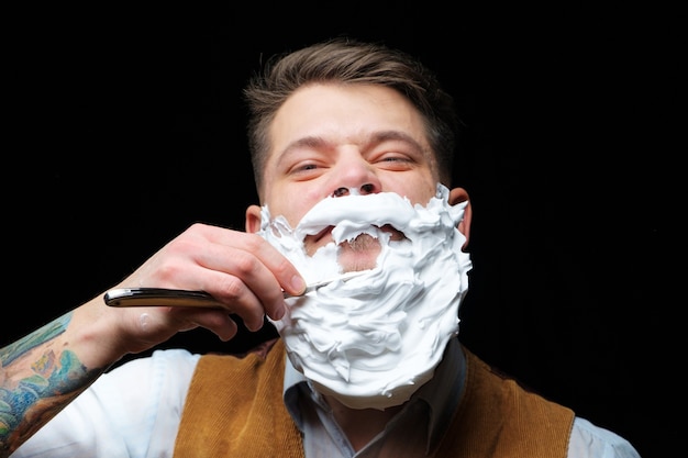 Retro shaving with foam in barber shop Closeup