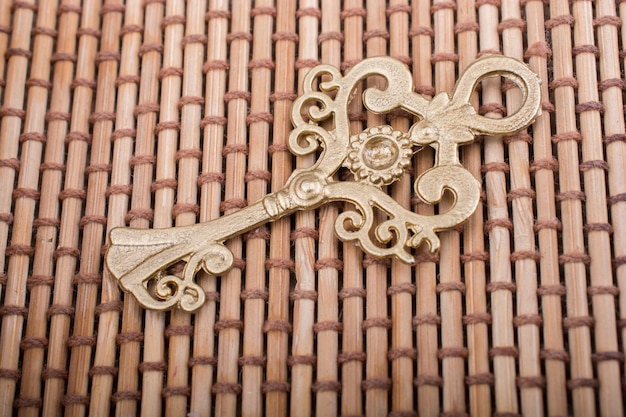 Foto retro stijl gouden kleur sleutel op een stro achtergrond