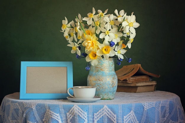 Photo retro still life with a bouquet of daffodils on a green background.