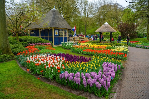 Retro stone well and tulips in Keukenhof park Lisse Holland Netherlands