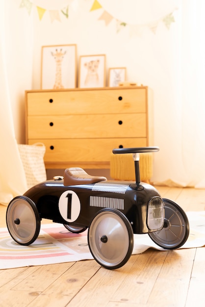 Photo retro style children's racing car in a children room.