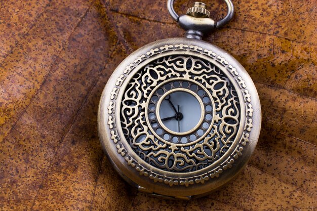 Photo retro style pocket watch placed on a piece of fabric