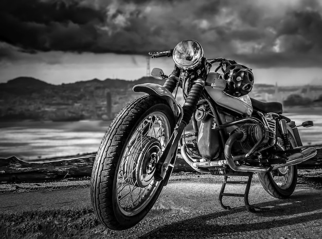 A retro-style sports motorcycle stands on Street against a cloudy sky