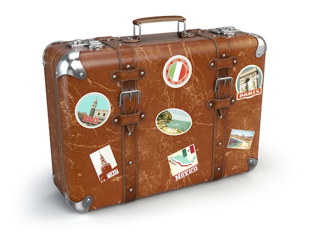 白で隔離される旅行のステッカーが付いているレトロなスーツケースの手荷物