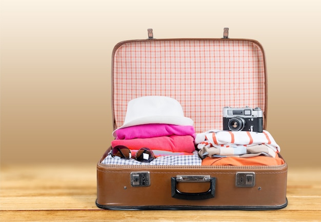 Retro suitcase with travel objects  on background