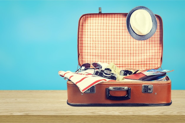 Retro suitcase with travel objects on light