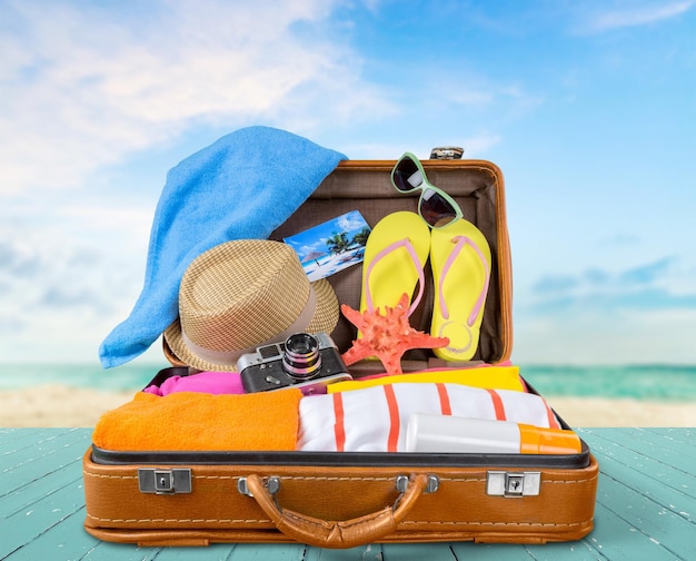 Retro suitcase with travel objects  on sea background