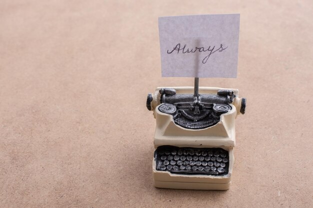 Retro syled tiny typewriter model on a brown background