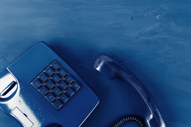 Photo retro telephone of blue color on classic blue background