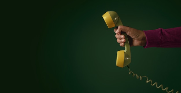 Photo retro telephone. hand holding a handset. communication concept.