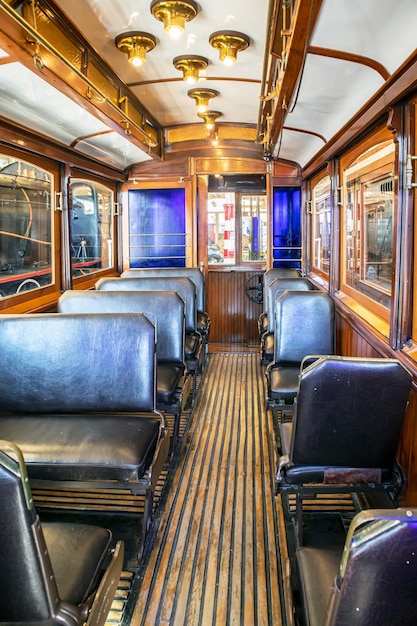 A Retro tram car with black seats and a wooden floor, Istanbul R.Koc Museum.