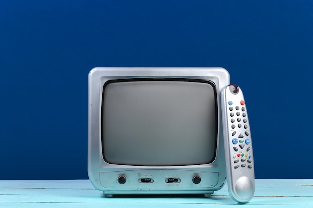 Retro tv receiver with tv remote on classic blue