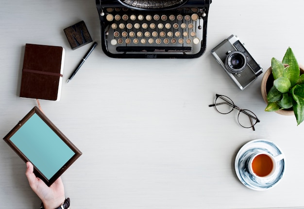 Retro Typewriter with Hand Holding Photo Wooden Frame on Gray Table