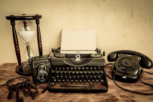 Retro typewriter with paper blank on wood table. Top view